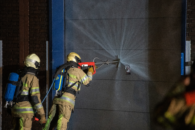 911069 Afbeelding van enkele brandweerlieden tijdens het blussen van de brand in het bedrijvenverzamelgebouw CAB-Rondom ...